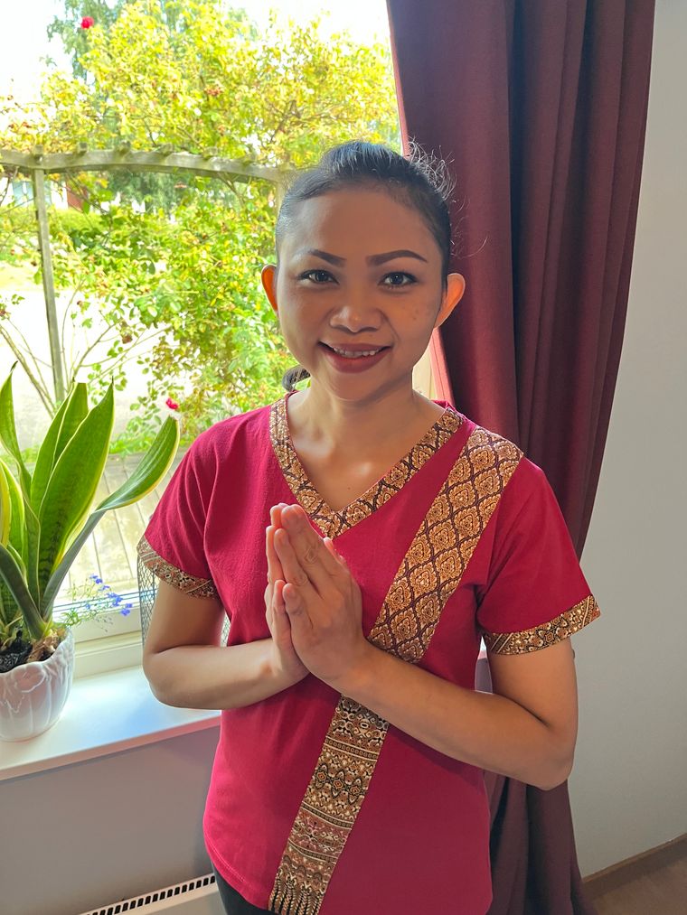 Kann, utbildad massös, hälsar välkommen till massage i Kalmar i traditionell thailändsk dräkt