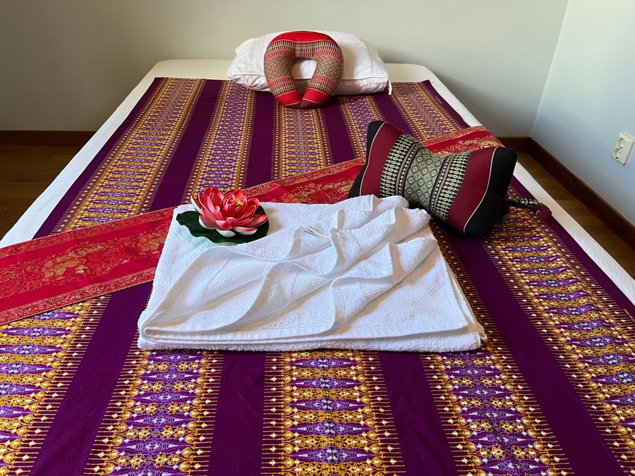 Behandlingsrummet för massage i Kalmar med bäddad massagebänk, thailändskt sidentyg och rena handdukar