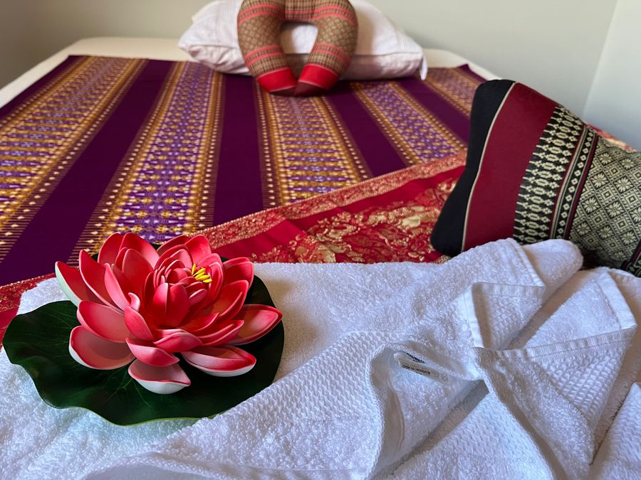 Massagebänken dekorerad inför en massagebehandling i Kalmar, med rena handdukar och lotusblomma